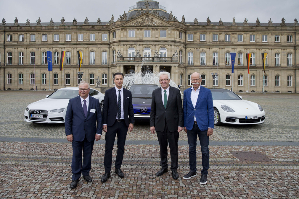 v.l.n.r.: Prof. Dr. Hubert Waltl (AUDI AG), Lutz Meschke (Porsche AG), Ministerpräsident Winfried Kretschmann und Dr. Dieter Zetsche (Daimler AG) stehen im Ehrenhof des Neuen Schlosses vor Elektrofahrzeugen.