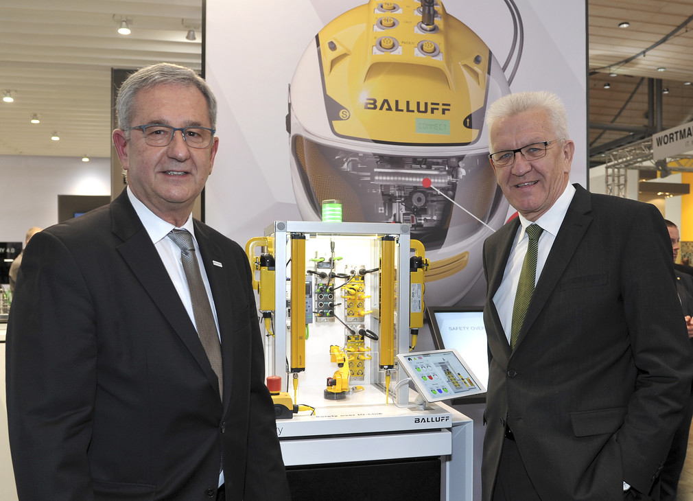 Ministerpräsident Winfried Kretschmann (r.) besucht den Stand der Fabrik- und Prozessautomationsspezialisten Balluff GmbH (Neuhausen)