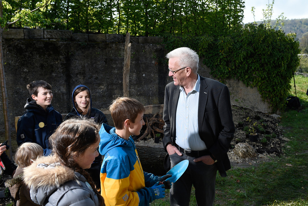 Ministerpräsident Winfried Kretschmann (r.) mit „Europa Minigärtnern“ im Garten des Clay-Hauses