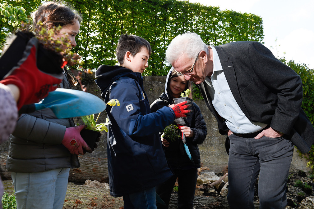 Ministerpräsident Winfried Kretschmann (r.) mit „Europa Minigärtnern“ im Garten des Clay-Hauses