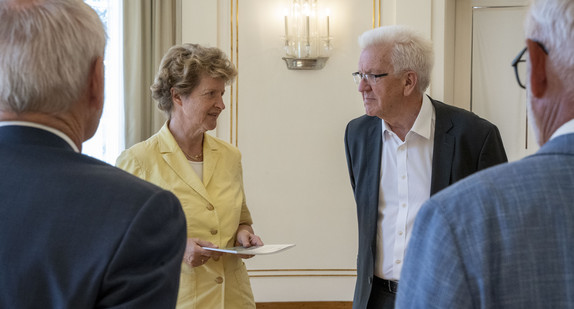 Dr. Gisela Meister-Scheufelen (zweite von links), Vorsitzende des Normenkontrollrats Baden-Württemberg, übergibt Ministerpräsident Winfried Kretschmann (zweiter von rechts) den Jahres- und Bilanzbericht 2021.