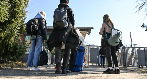 Flüchtlinge aus der Ukraine warten an der Hauptpforte der Landeserstaufnahmeeinrichtung, um hereingelassen zu werden.