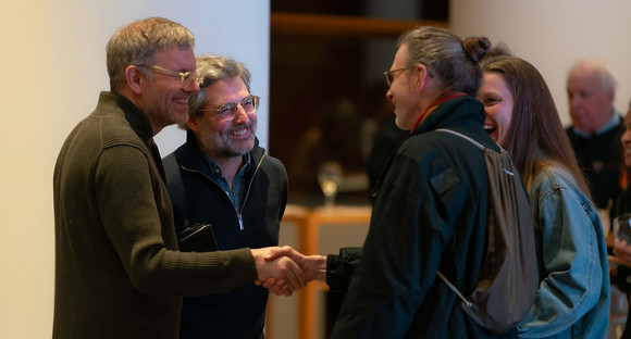 Gäste und Jo Ambros unterhalten sich im Foyer der Landesvertretung