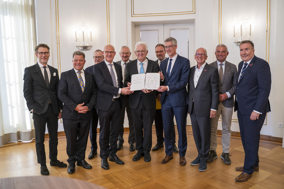 Ministerpräsident Winfried Kretschmann (Mitte), Innenminister Thomas Strobl (zweiter von rechts) und Staatsminister Dr. Florian Stegmann (links) mit Vertretern der Kommunalen Landesverbände sowie von Wirtschafts- und Finanzverbänden nach der Unterzeichnung der gemeinsamen Entlastungsallianz für Baden-Württemberg im Runden Saal der Villa Reitzenstein in Stuttgart.