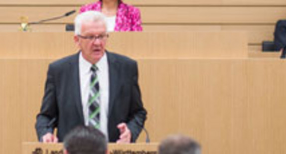 Ministerpräsident Kretschmann spricht am Rednerpult im Landtag von Baden-Württemberg (Bild: © dpa).