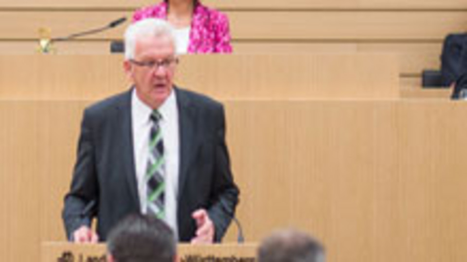 Ministerpräsident Kretschmann spricht am Rednerpult im Landtag von Baden-Württemberg (Bild: © dpa).