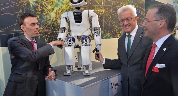 v.l.n.r.: Finanz- und Wirtschaftminister Nils Schmid, Ministerpräsident Winfried Kretschmann und Minister Peter Friedrich mit einem Roboter