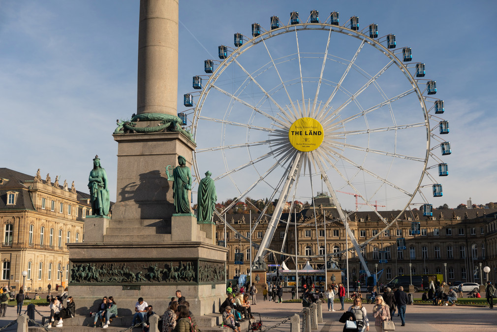 Riesenrad auf dem Stuttgarter Schlossplatz mit der Aufschrift „Beste Aussichten: THE LÄND“ und dem Landeswappen