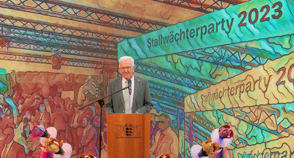 Ministerpräsident Winfried Kretschmann begrüßte die Gäste der 58. Stallwächterparty. Es steht vor einer KI-gesteuerten LED-Wand im Garten der Landesvertretung.