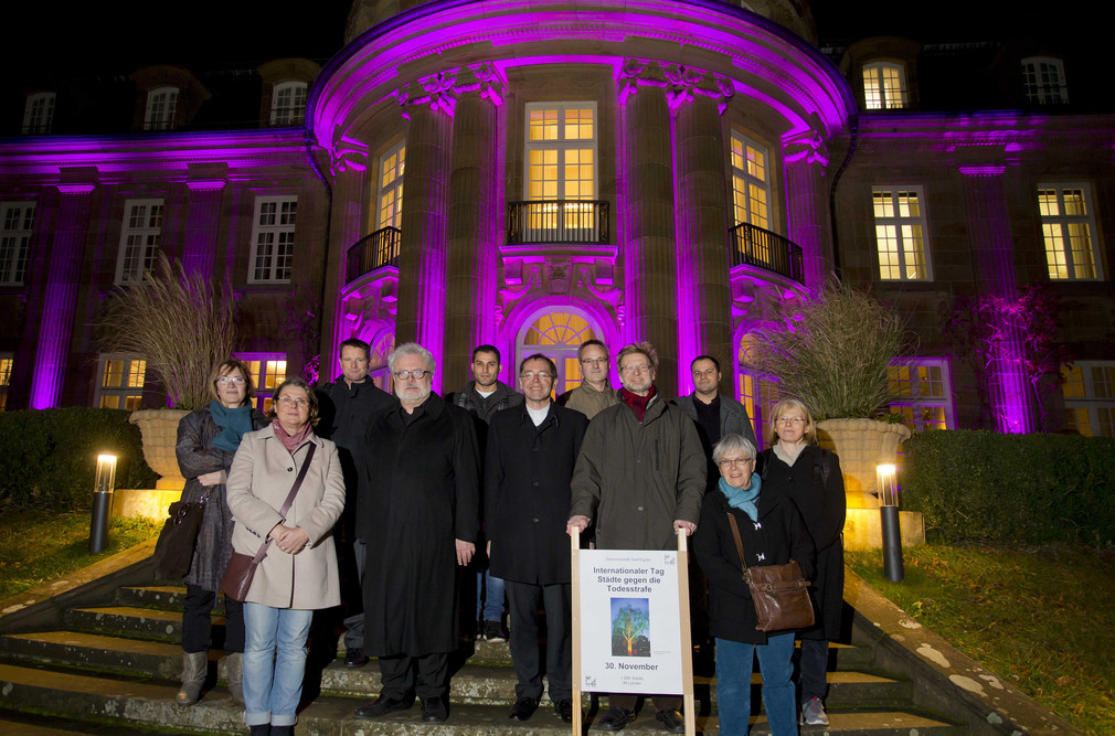 Gruppenfoto mit Klaus-Peter Murawski (4.v.l.) vor der beleuchteten Villa Reitzenstein.