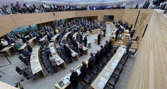 Abgeordnete und Besucher des Landtags von Baden-Württemberg stehen bei einer Schweigeminute für alle Opfer antisemitischer Verbrechen anlässlich einer Debatte zum Kampf gegen Antisemitismus im Plenarsaal in Stuttgart. 