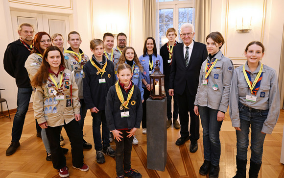 Jugendliche Pfadfinderinnen und Pfadfinder übergeben Ministerpräsident Winfried Kretschmann (dritter von rechts) das Friedenslicht aus Bethlehem.