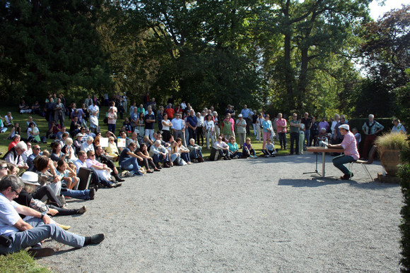 Mike Zaka Sommerfeldt (r.) liest im Park.