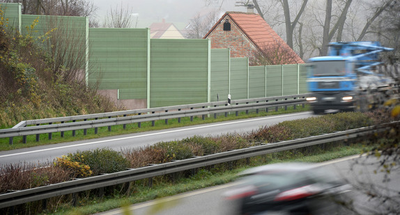 Ein Laster fährt auf der Bundesstraße 30 an der Ortschaft Baltringen vorbei, die durch Lärmschutzwände von der Bundesstraße getrennt ist (Bild: © dpa). 