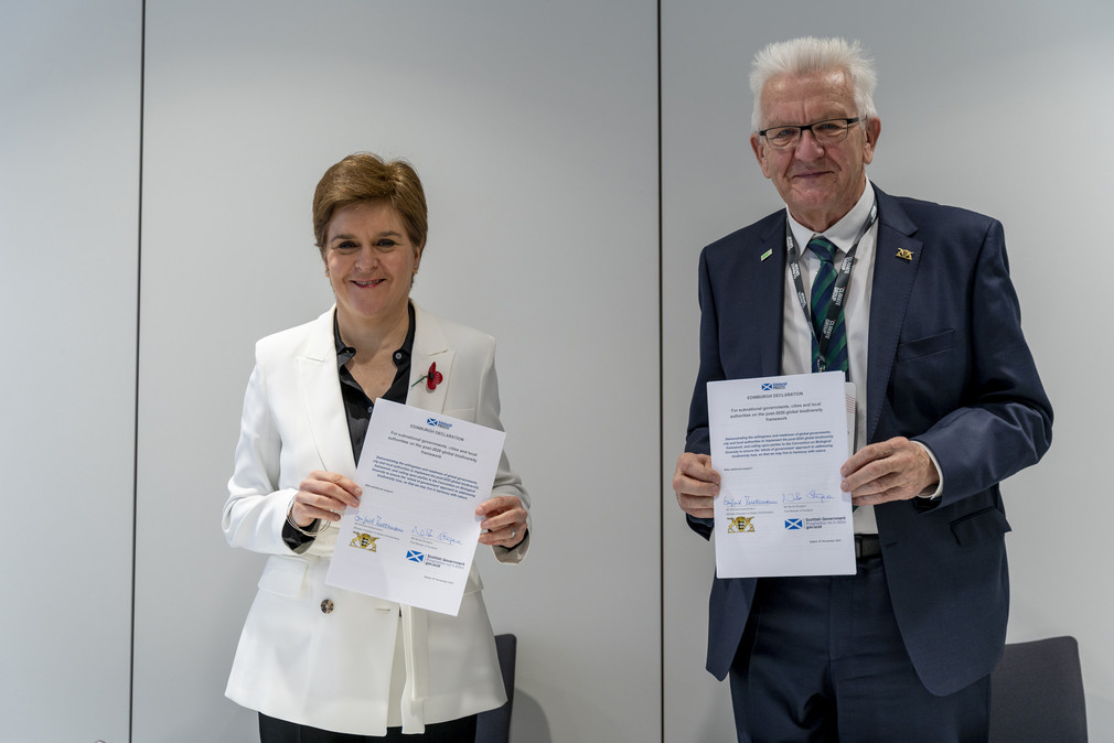 Schottlands Regierungschefin Nicola Sturgeon (links) und Ministerpräsident Winfried Kretschmann (rechts) halten jeweils eine unterzeichnete Edinburgh-Erklärung in den Händen.