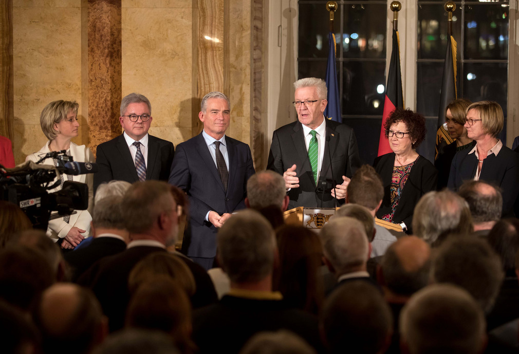 Ministerpräsident Winfried Kretschmann (M.) und Ehefrau Gerlinde (3.v.r.) mit den Mitgliedern des Kabinetts vor den Gästen