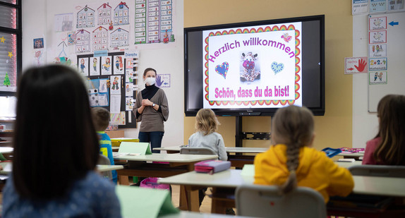 Eine Lehrerin mit FFP2-Maske unterrichtet in einer ersten Klasse an einer Grundschule mit Wechselunterricht. 