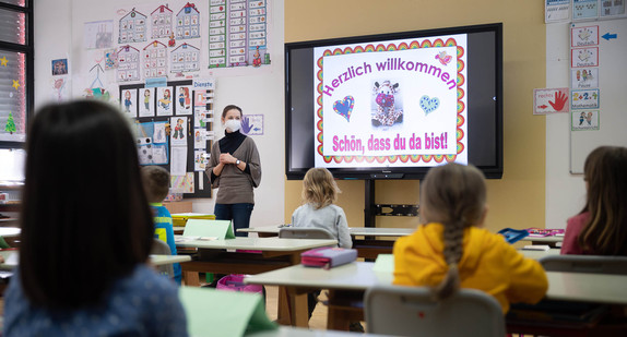 Eine Lehrerin mit FFP2-Maske unterrichtet in einer ersten Klasse an einer Grundschule mit Wechselunterricht. 