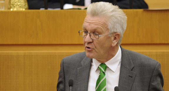 Ministerpräsident Winfried Kretschmann am Rednerpult im Landtag während einer Debatte.
