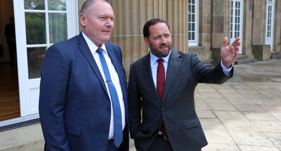 Staatssekretär Florian Hassler (rechts) und der Botschafter der Republik Moldau, Aureliu Ciocoi (links), stehen vor der Villa Reitzenstein.
