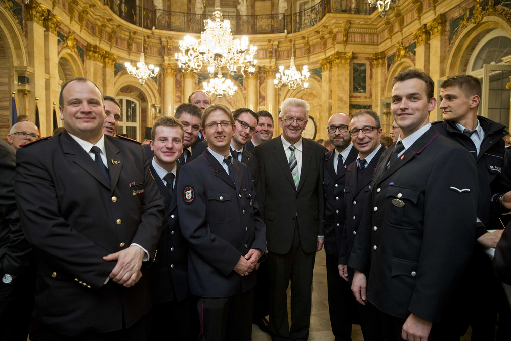 Ministerpräsident Winfried Kretschmann (M.) mit Feuerwehrleuten