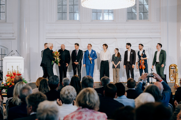 Ministerpräsident Winfried Kretschmann (links) dankt den Künstlerinnen und Künstlern