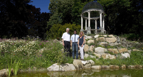 von links nach rechts: Ministerpräsident Winfried Kretschmann, Dr. Andre Baumann, Landesvorsitzender NABU Baden-Württemberg, und Katja Siegmann, Landschaftsarchitektin bei der Wilhelma, am naturnah gestalteten Teich im Garten der Villa Reitzenstein