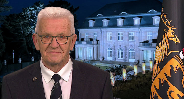 Ministerpräsident Winfried Kretschmann bei seiner Ansprache zum Jahreswechsel 2025/2026, im Hintergrund die Villa Reitzenstein, rechts im Bild die Baden-Württemberg-Fahne.