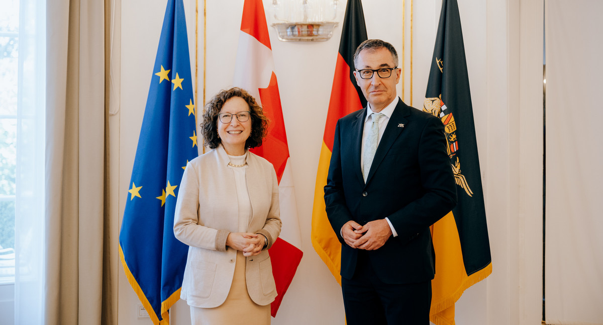 Ministerpräsident Özdemir und die kanadische Botschafterin vor den Flaggen der Europäischen Union, Kanadas, Deutschlands und Baden-Württembergs.