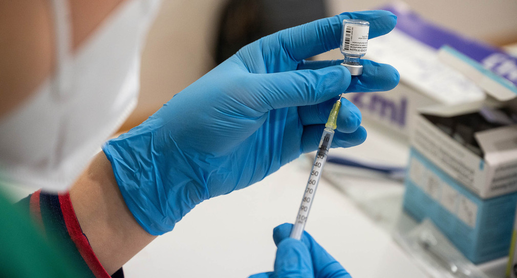 Die Mitarbeiterin eines mobilen Impfteams zieht in einem Alten- und Pflegeheim den Impfstoff von Biontech/Pfizer in eine Spritze auf.