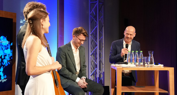 Kultur Brahms Liederabend: Wie komm' ich denn zur Tür herein? Theresa Pilsl, Leonard Becker und Jonas Müller stehen auf der Bühne und führen ein Gespräch mit Dienststellenleiter Stephan Ertner. Die Atmosphäre ist herzlich und entspannt.