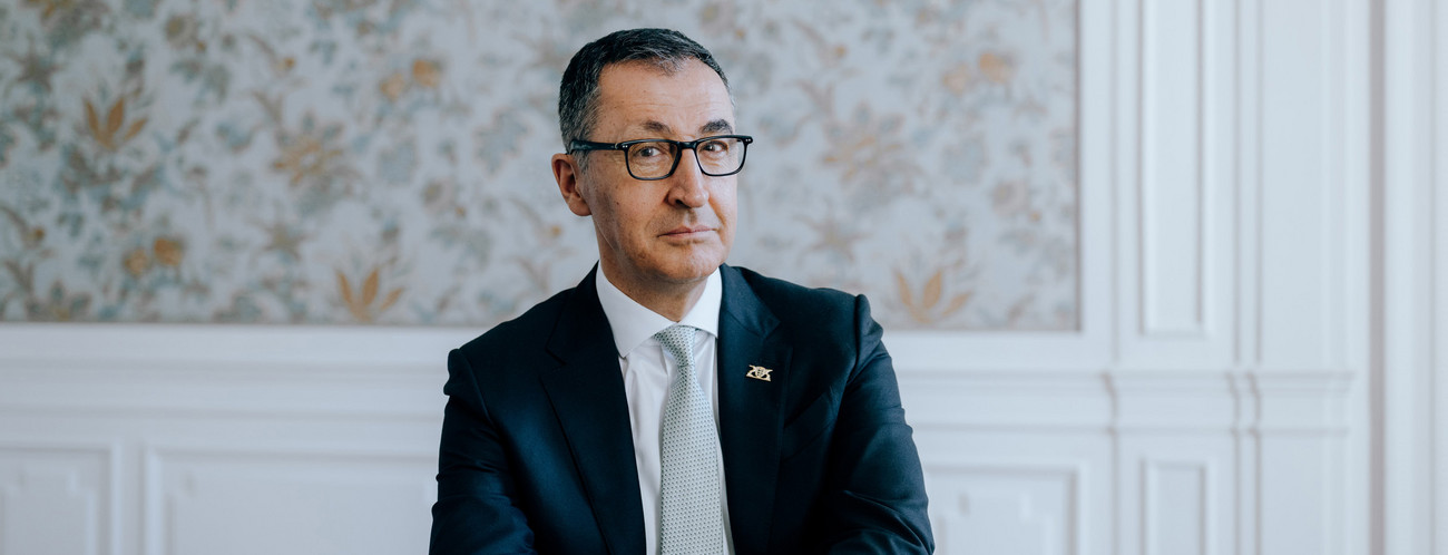 Portraitbild von Ministerpräsident Cem Özdemir, an einem Tisch sitzend.