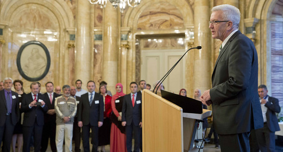 Ministerpräsident Winfried Kretschmann (r.) spricht beim Iftar-Empfang