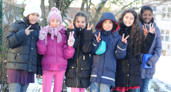 Eine Gruppe Grundschülerinnen unterschiedlicher Herkunft stehen auf dem Pausenhof zusammen (Bild: © Ministerium für Kultus, Jugend und Sport BW).