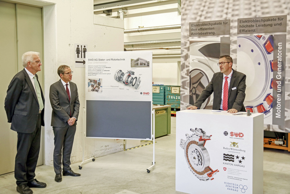 Ministerpräsident Winfried Kretschmann (l.) und Landstatthalter Dr. Urs Hoffmann (2.v.l.) beim Besuch der SWD AG Stator- und Robotertechnik im Kanton Aargau