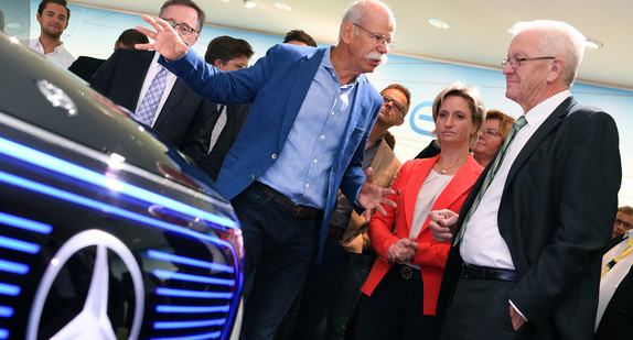 Dieter Zetsche (M.), Vorstandsvorsitzender der Daimler AG, zeigt Ministerpräsident Winfried Kretschmann (r.) und Wirtschaftsministerin Nicole Hoffmeister-Kraut (2.v.r.) beim Rundgang über die Internationale Automobil-Ausstellung (IAA) in Frankfurt am Main den Mercedes-Benz EQ concept. (Foto: © dpa)