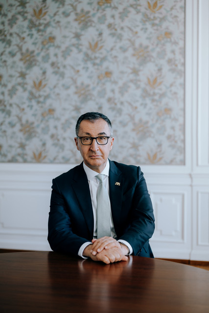 Portraitbild von Ministerpräsident Cem Özdemir, an einem Tisch sitzend.
