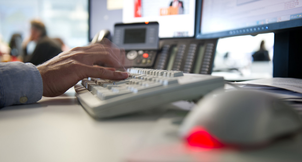 Ein Mann tippt in einem Büro auf einer Tastatur. (Bild: © dpa)