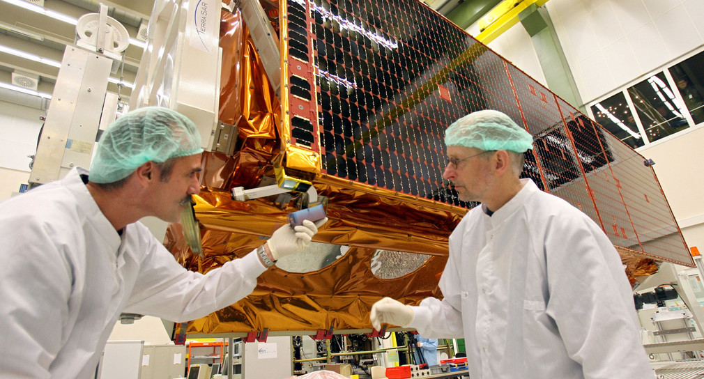 Zwei Mitarbeiter erledigen letzte Arbeiten an dem Sende- und Empfangsgerät des Satelliten TerraSar-X. (Foto: dpa)