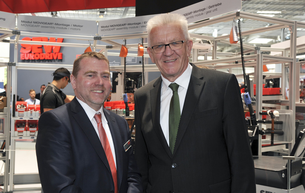 Ministerpräsident Winfried Kretschmann (r.) besucht den Stand der SEW-EURODRIVE GmbH & Co. KG (Bruchsal)