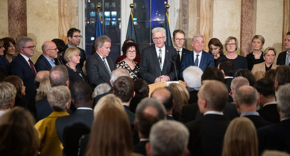 Ministerpräsident Winfried Kretschmann (M.) und seine Ehefrau Gerlinde stehen mit Mitgliedern der Landesregierung vor den Gästen. (Bild: © picture alliance/Marijan Murat/dpa)