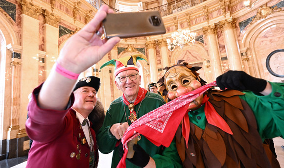 Narren machen ein Selfie mit Ministerpräsident Winfried Kretschmann (Mitte).