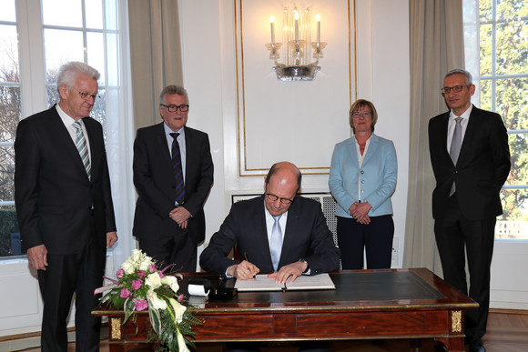 Matthias Grewe (sitzend), Vorsitzender des Vereins der Richter und Staatsanwälte Baden-Württemberg e.V., unterzeichnet die Vereinbarung; stehend v.l.n.r.: Ministerpräsident Winfried Kretschmann, Volker Stich, Vorsitzender des Beamtenbundes Baden-Württemberg, Finanzministerin Edith Sitzmann  und Staatssekretär Martin Jäger