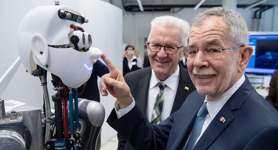 Der österreichische Bundespräsident Dr. Alexander Van der Bellen (r.) und Ministerpräsident Winfried Kretschmann (l.) betrachten beim Cyber Valley am Max-Planck-Institut für Intelligente Systeme in Tübingen den Roboter Apollo (Bild: © dpa)