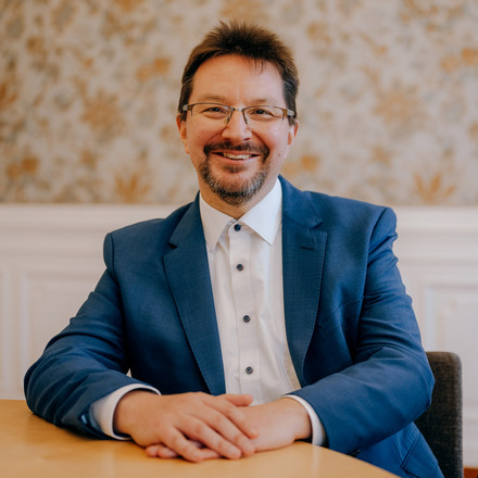 Porträtbild von Dr. Michael Blume, an einem Tisch sitzend.