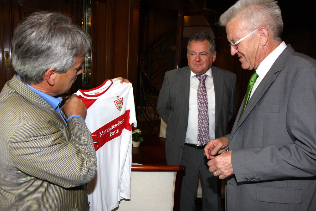 Gerd E. Mäuser (l.), Präsident des VfB Stuttgart, übergibt Ministerpräsident Winfried Kretschmann (r.) ein neues Trikot des VfB Stuttgart.