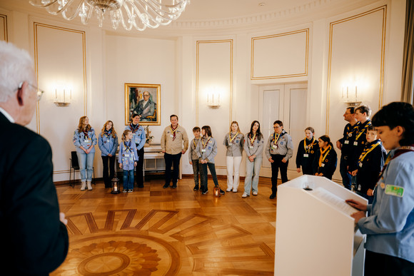 Ministerpräsident Winfried Kretschmann (rechts) mit Pfadfinderinnen und Pfadfindern bei der Übergabe des Friedenslichts