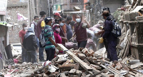Menschen in den Trümmern der durch ein Erdbeben zerstörten Häuser in Sakhu/Nepal (Foto: © dpa)