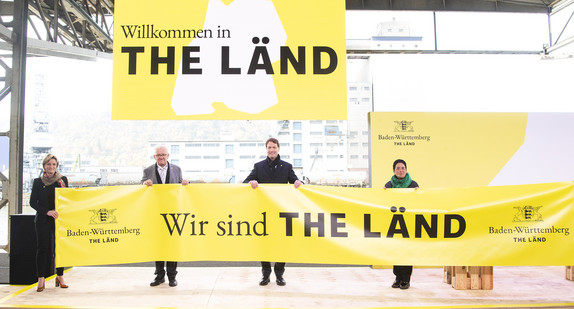 v.l.n.r.: Moderatorin Kimsy von Reischach, Wirtschaftsministerin Dr. Nicole Hoffmeister-Kraut, Ministerpräsident Winfried Kretschmann, Ola Källenius, Vorstandsvorsitzender der Daimler AG, und die Zwei-Sterne-Köchin Douce Steiner halten ein Transparent mit der „Wir sind THE LÄND“.