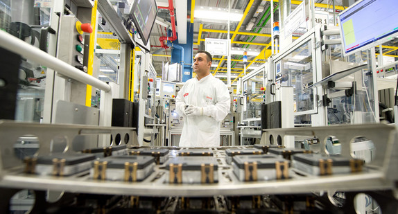 Ein Facharbeiter steht im Bosch Werk in Reutlingen vor einer Charge von Radarsensoren für die Automobilindustrie (Bild: © dpa). 